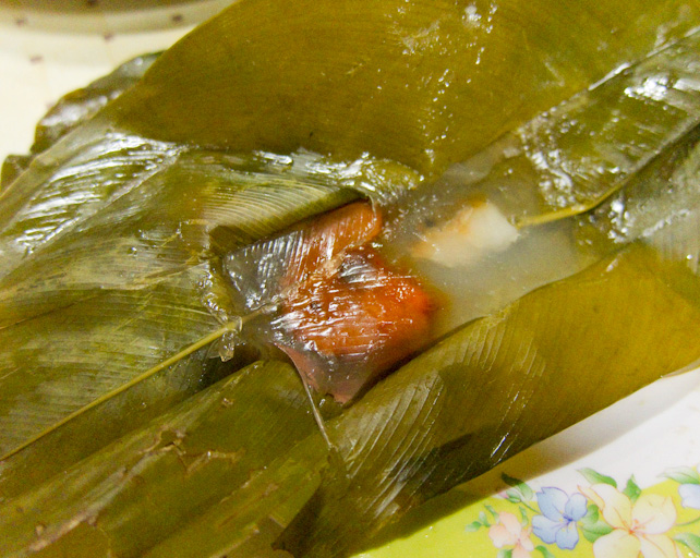 Bánh bột lọc gói lá mở ra thấy nhân tôm màu cam bên trong