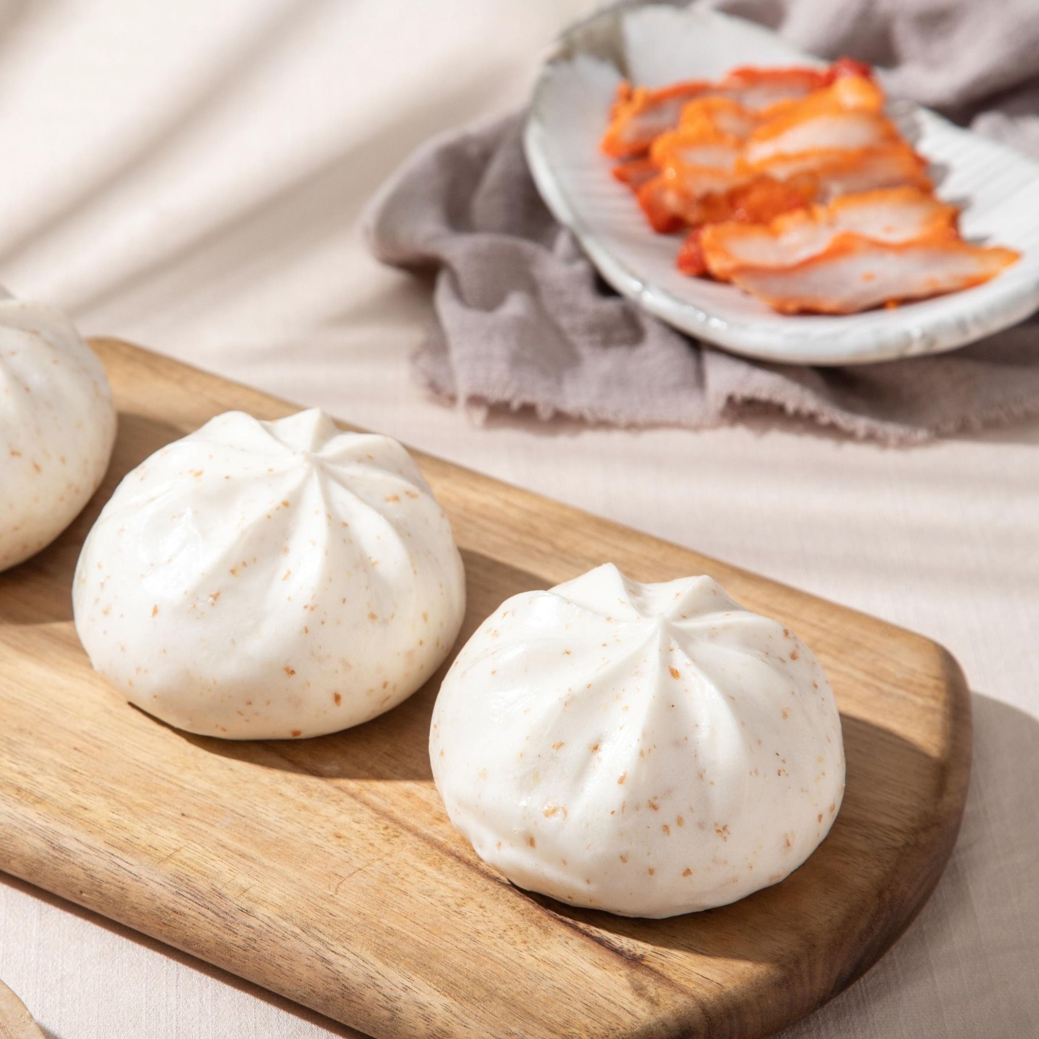 Bánh bao xá xíu hấp đặt trên bàn gỗ
