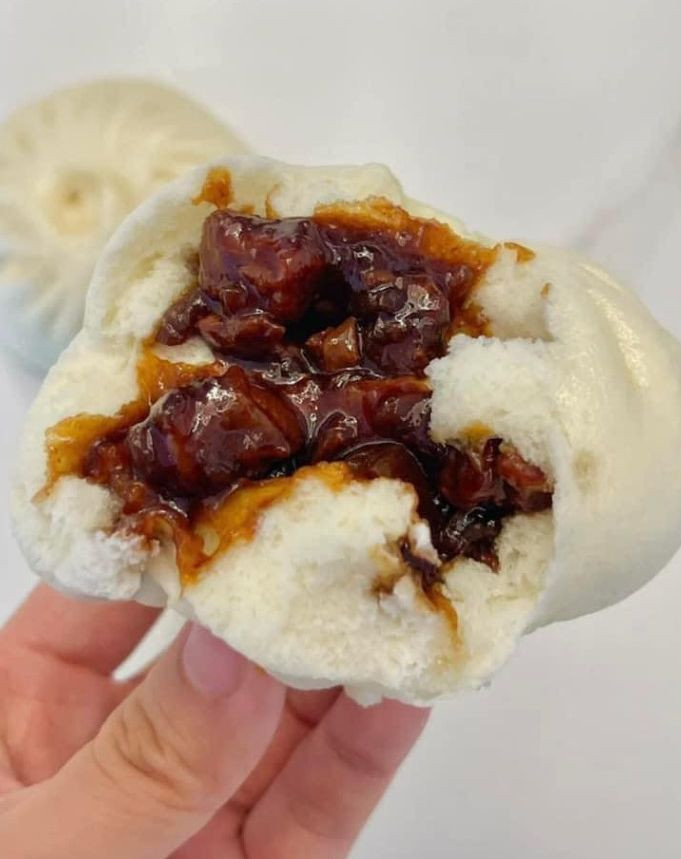 Bánh bao xá xíu được xé mở phần nhân sốt đậm